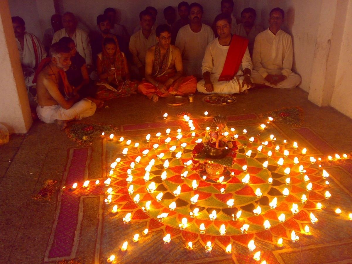 A night puja with a rangoli of hundreds of lit diyas